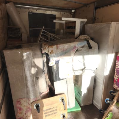 ציוד ארוז בתוך משאית הובלה עם שם עסק ומספר טלפון