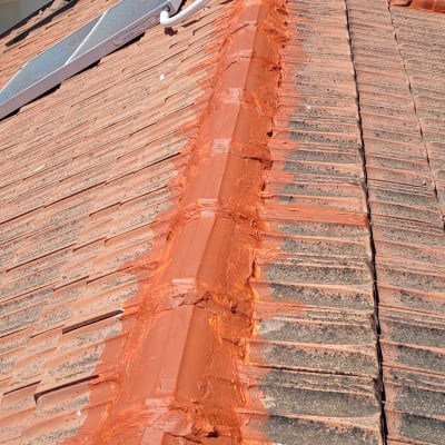 גג רעפים עם חומר איטום כתום לאורך החיבור