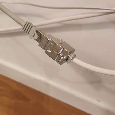 כבל רשת מחובר למחבר מתכת על קיר