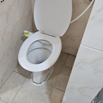 אסלה עם נזילה על הרצפה בחדר אמבטיה