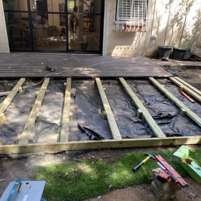 מסגרת עץ לבניית דק בגינה עם כלים על הקרקע