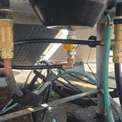 תקריב של חיבורי צנרת ושסתומים בתחתית דוד שמש על גג