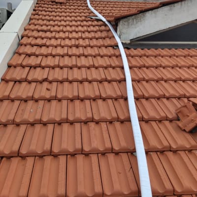 צינור לבן על גג רעפים אדום עם דודי שמש