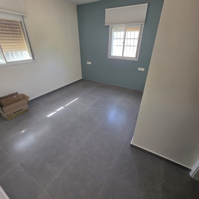 חדר צבוע עם קיר כחול ורצפת אריחים אפורה