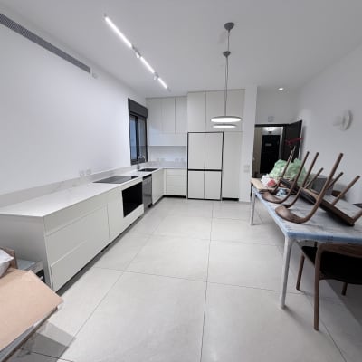 מטבח נקי ומסודר עם שולחן וכיסאות הפוכים