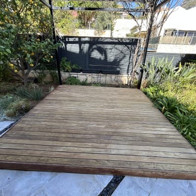 דק עץ בגינה עם צמחייה מסביב