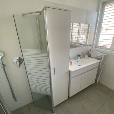 מקלחון זכוכית עם ידית מתכת בחדר אמבטיה