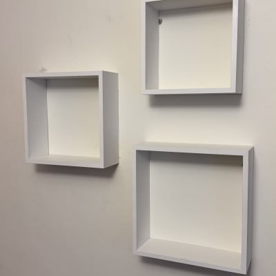 שלושה מדפים מרובעים לבנים על קיר לבן