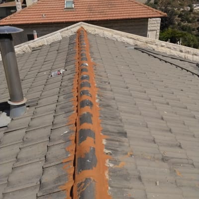 איטום גג עם חומר איטום כתום לאורך הרכס