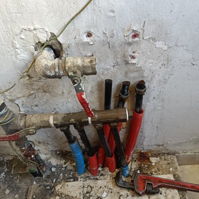צינורות מים עם ברזים וכלי עבודה על הקיר