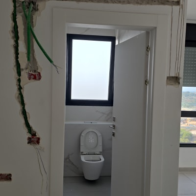 חשמל חשוף בקיר עם חוטים ירוקים וכחולים