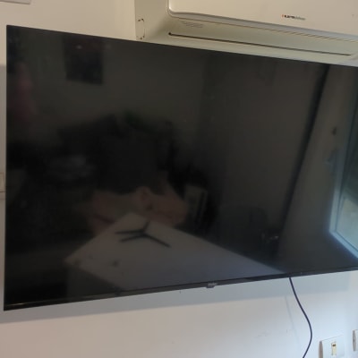 טלוויזיה מותקנת על קיר ליד מזגן ושקע חשמל