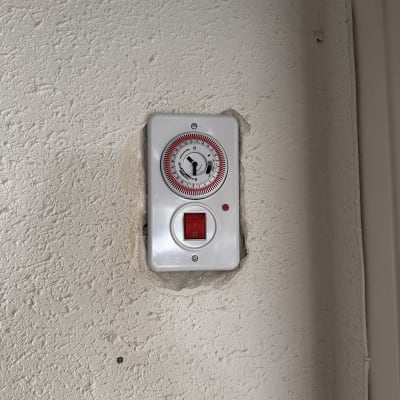 מתג חשמלי עם שעון טיימר על קיר