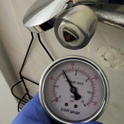 מד לחץ מים ליד ברז במקלחת