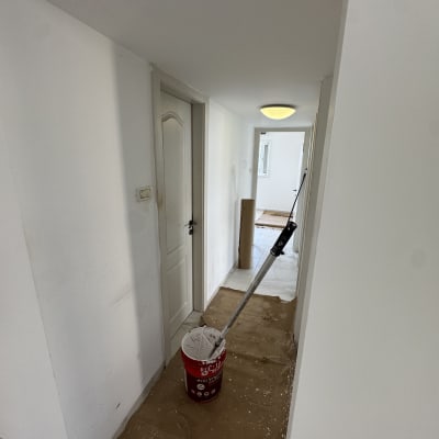 מסדרון צבוע עם דלי צבע ומברשת על הרצפה