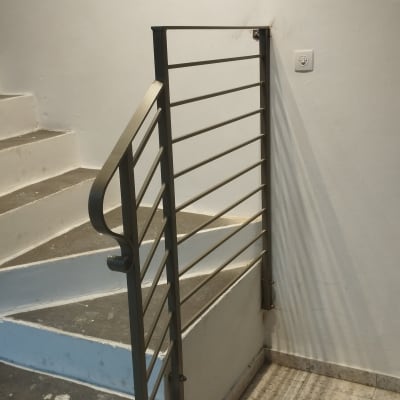 מעקה מתכת עם שלבים אופקיים ליד מדרגות