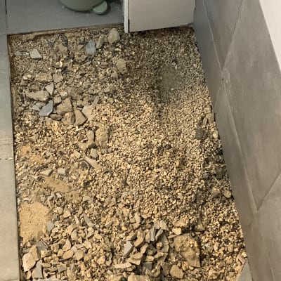 רצפה שבורה עם חצץ ואבנים קטנות בשיפוץ