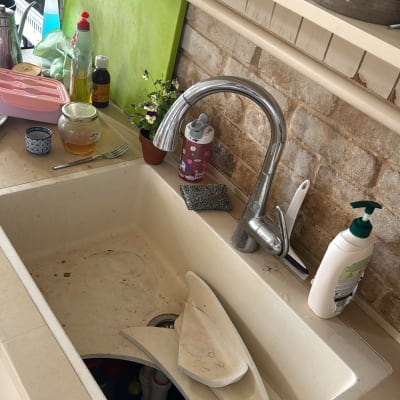 כיור מטבח עם כלים שבורים וברז נירוסטה