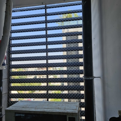 רשת מתכת על חלון למניעת כניסת יונים