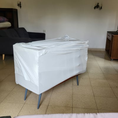 רהיט עטוף בניילון מוכן להובלה בחדר מגורים