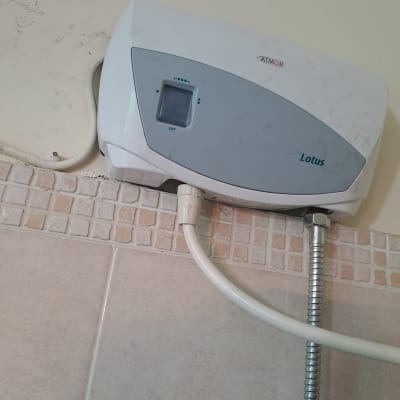 מחמם מים חשמלי מותקן על קיר עם חיבורים