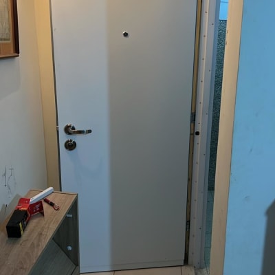 דלת לבנה עם ידית מתכת ובריח