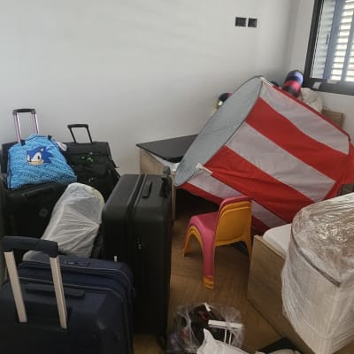 חדר עם מזוודות, צעצועים וציוד ארוז לארגון הבית