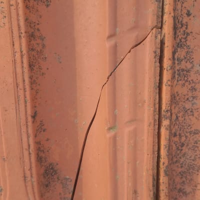 תקריב של רעף גג סדוק עם כתמים כהים