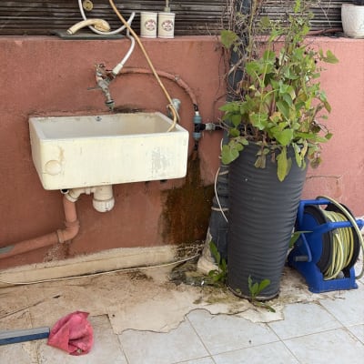 כיור חיצוני עם צינור ומיכל מים