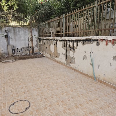 קיר מתקלף עם סימני שיפוץ, צינור ירוק על הרצפה