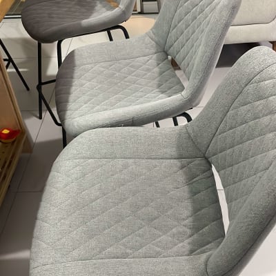 כיסאות מרופדים אפורים על רצפת אריחים לבנה