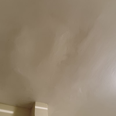 תקרה עם כתמי רטיבות ליד מנורה עגולה