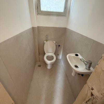 שירותים עם כיור קטן וחלון עליון