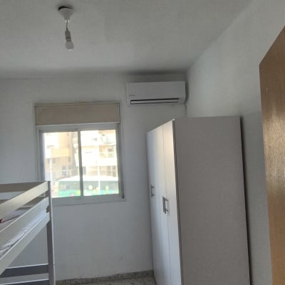 מזגן מותקן בחדר עם מיטת קומותיים וארון