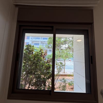 חלון זכוכית נקי ומבריק בתוך חדר לאחר עבודת ניקוי חלונות