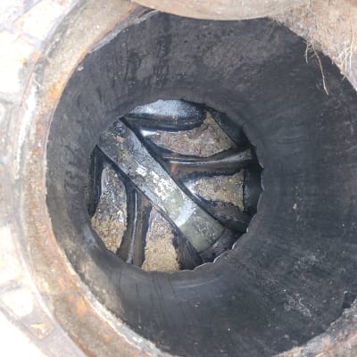 פתח ביוב עם צינורות מתכת חלודים