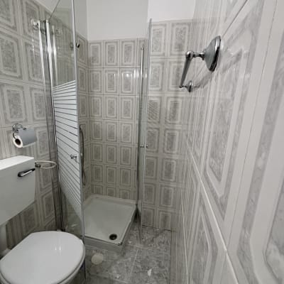 מקלחת עם דלת זכוכית ושירותים בחדר אמבטיה