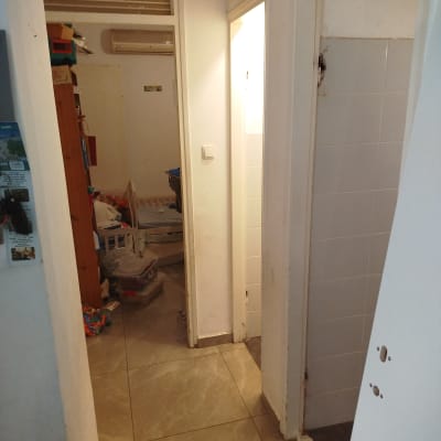 מסדרון עם דלתות פתוחות וחלקי קיר חשופים