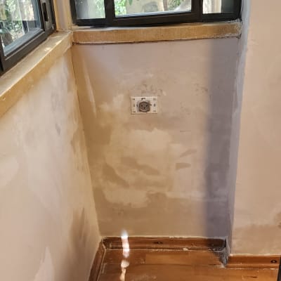 קיר צבוע ליד חלון עם עצים בחוץ