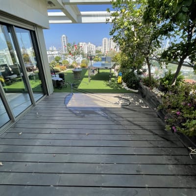 מרפסת עץ עם שולחן פינג פונג וצמחים מסביב