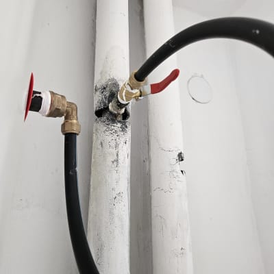 צינור שחור עם ברז אדום מחובר לדוד שמש