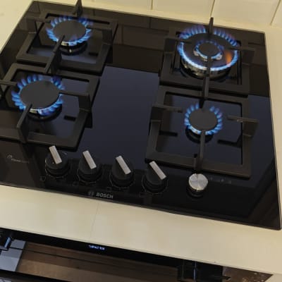 כיריים גז עם ארבעה מבערים דולקים