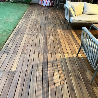 דק עץ בגינה עם ריהוט גן וכיסאות