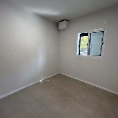 חדר ריק עם קירות צבועים בלבן ותקרה בהירה