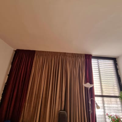 וילונות תלויים על חלון עם מנורת קריאה