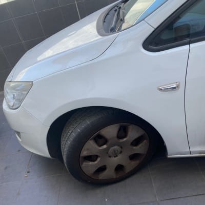 חלק קדמי של רכב עם גלגל ולוחית