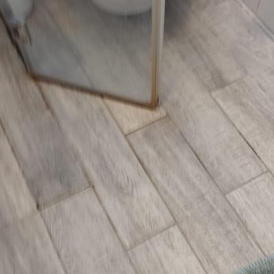 מקלחון עם רצפת עץ ומגבת ירוקה