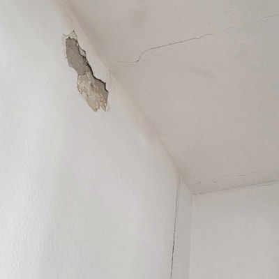 קיר עם סדקים וקילוף צבע בתקרה