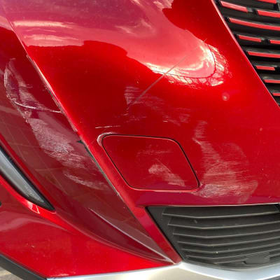 פגוש רכב אדום עם שריטות ונזק קל