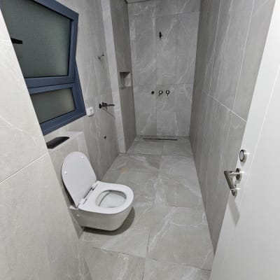 שירותים נקיים עם קירות ורצפה מאבן אפורה